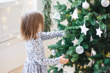 Oda yeni yıl için dekore edildi, kız Noel ağacının yanında oturuyor, hediyeler, Noel 'i bekliyor, ev konforu.