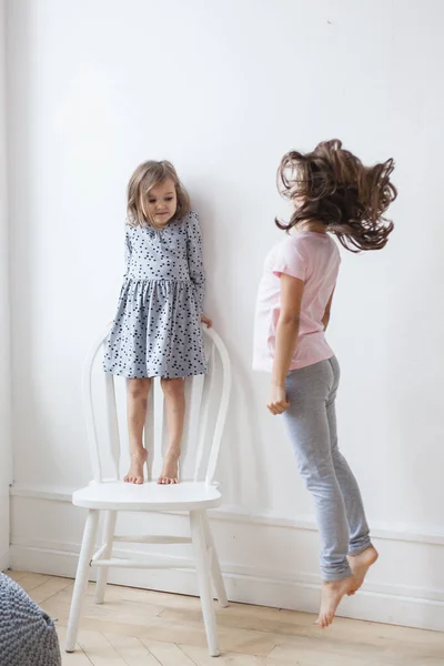 Filles Sœurs Près Mur Blanc Une Chaise Mesure Hauteur Jeux — Photo