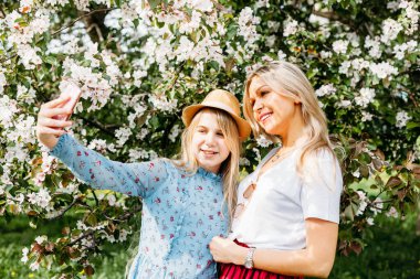 Kız, annesi olan kız, çiçek açan elma ağaçları, çiçekler, dallar, bahar, yaz, güzellik, doğa, iletişim, aile, öpüşme, toplantı, kitap okumak, konuşmak.