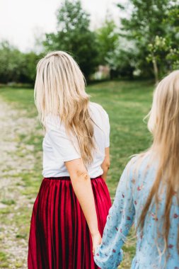 Anne kızının elinden tutup çiçek açan ağaçlara götürüyor. Şehirde, parkta ya da ormanda yürüyor.