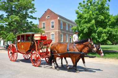 Horse drawn carriage tours in British Colony in Williamsburg, Virginia VA, USA. clipart