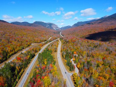 Otoyol I-93 boyunca Franconia Notch 'u Cannon Dağı ile Lafayette Dağı arasında geçerek White Mountain, Lincoln, New Hampshire NH, ABD' deki Franconia Notch State Park 'ta sonbahar yeşillikleri ile kaplandı.. 