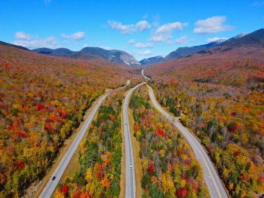 Otoyol I-93 boyunca Franconia Notch 'u Cannon Dağı ile Lafayette Dağı arasında geçerek White Mountain, Lincoln, New Hampshire NH, ABD' deki Franconia Notch State Park 'ta sonbahar yeşillikleri ile kaplandı.. 