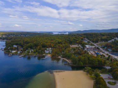 Winnipesaukee Gölü ve Weirs Sahili hava manzaralı köy Laconia City, New Hampshire NH, ABD 'de sonbahar yeşillikleri ile. 