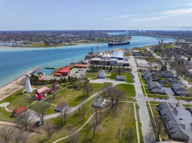 Fort Gratiot Lighthouse aerial view at the entrance to the St. Clair River from Lake Huron, with Blue Water Bridge at the distance, in city of Port Huron, Michigan MI, USA. 