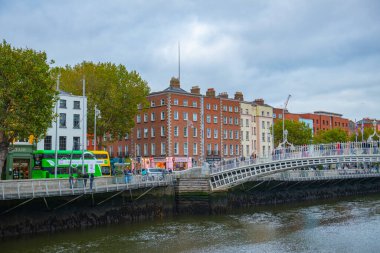 River Liffey 'in kuzey kıyısındaki tarihi ticari binalar Ormond Quay Lower' da eski Dublin, İrlanda 'daki yarım peni köprüsü ile.