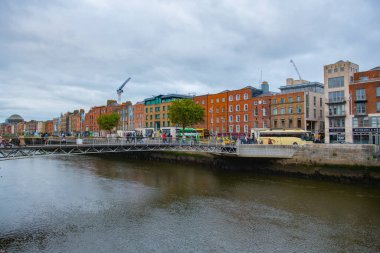 River Liffey 'in kuzey kıyısındaki tarihi ticari binalar Ormond Quay Lower' da eski Dublin, İrlanda 'daki Milenyum Köprüsü ile.