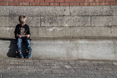 Liverpool, İngiltere - 03 Ocak 2019: Çocuk koridorda oturuyor ve Mersey Nehri 'ndeki koridorda bir şey izliyor, Royal Albert Rıhtımı. Uzayı kopyala, odaklan ve bulanıklaştır.