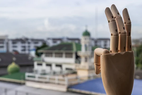 Wooden Hand Puppet showing three fingers hand on a city background. Symbolic support for democracy, Copy space.