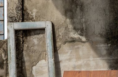 Çatlakları olan eski bir beton duvarın arka planına dayanan eski bir ahşap kapı çerçevesi. Metnin için boşluk. Özellikle odak yok..
