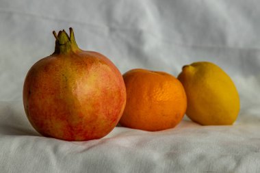 Beyaz arka planda taze meyve, nar, portakal ve limon. Seçici odak.