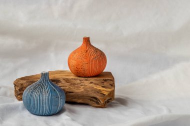 Beyaz zemin üzerinde ahşap kütükler olan iki güzel küçük seramik vazo. Seramik sofra takımı, ev dekorasyonu.