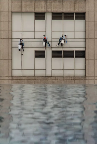 Grupa Pracowników Sprzątających Okna Wysokim Budynku Biurowym Odbiciem Basenu Skupienie — Zdjęcie stockowe