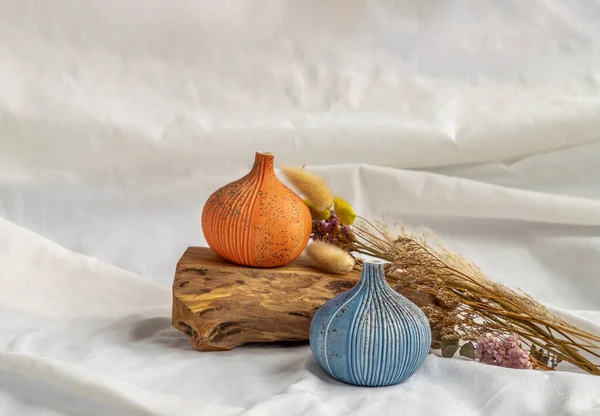 两个漂亮的小瓷瓶 木制原木和白色背景的干花 陶瓷餐具 家居装饰 — 图库照片