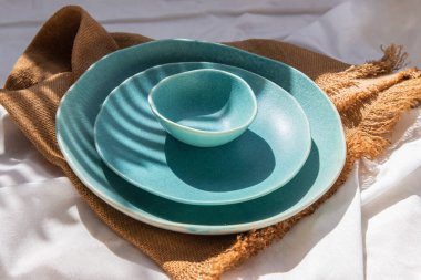 Beyaz arka planda çuval bezi dekoratif tekstil seramik tabaklar. Seramik sofra takımı, Güzel düzenleme.