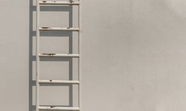 Duvara bağlı beyaz metal yangın merdiveni ve bir binanın çatısına çıkıyor. Boşluğu kopyala, Seçici odak.