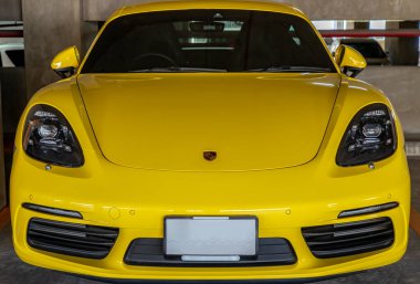 Bangkok, Tayland - 06 Ocak 2021: Otoparka park edilmiş sarı Porsche Spor Arabası 'nın önünde. Seçici odak.