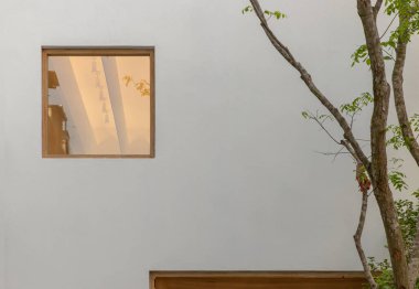 Beyaz duvarlardaki cam pencereye yansıyan binalar. Seçici odak.