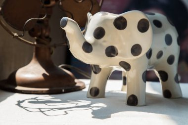 Filler beyaz desenli masa örtüsü üzerinde seramik ve vintage metal yelpaze şeklinde. Ev dekorasyonu, özellikle odak yok..