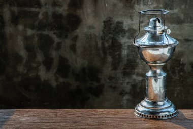 Köhne ahşap arka planda eski beton duvarlı eski bir gaz lambası. Vintage, Retro, Kopyalama alanı, Seçici odak.