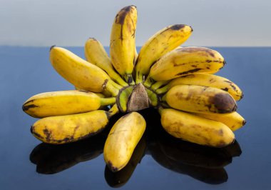 Bir demet Bayan Parmak Muzları. Siyah masada Tropikal Meyve Doğal Ürünleri. Seçici odak.
