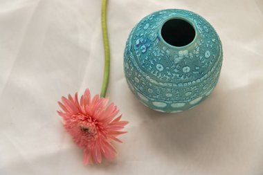 Mavi seramik vazo ve pembe çiçek desenli masa örtüsü. Ev dekorasyonu, Boşluğu Kopyala, Seçici odak.