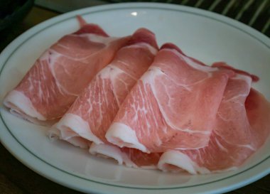 Dilimlenmiş domuz omuzu ve çizgili domuz pastırması fırında ızgara servis edilmeye hazır tabakta güzelce düzenlenmiştir. Kore usulü barbekü. Seçici odak.