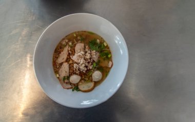 Tayland baharatlı şehriye çorbası, domuz eti ve beyaz seramik kasede balık köftesi. Üst Görünüm, Boşluğu Kopyala, Seçici Odaklanma.
