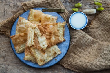 Ev yapımı tatlı çıtır Thai Roti (Tayland gözlemesi) seramik tabakta tatlandırılmış yoğunlaştırılmış sütle servis edilir. Lezzetli Tayland Tatlısı, Seçici odak.