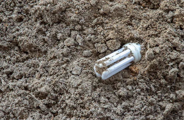 Remains Burnt Energy Saving Lamp Left Beach Sand Hazardous Toxic — Stock Photo, Image