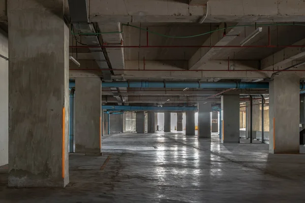 Vacant parking lot in car park building at condominium. Empty car parking garage in the afternoon. Selective focus.