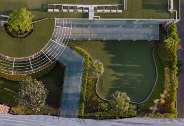 Bangkok, Tayland - 10 Mayıs 2021: Yeşil bahçenin yukarıdan aşağı havadan görünüşü ve apartman dairesindeki golf sürüş poligonu. Modern manzara mimarisi. Seçici odak.