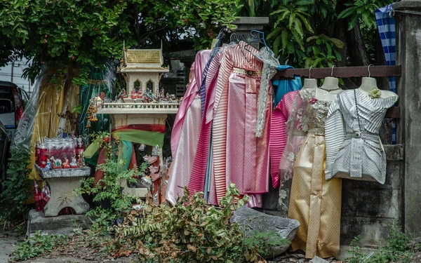 A spirit house or Joss house built for guardian spirit to reside with Traditional thai costumes and Red soft drink is the belief of the Thai villagers. Selective focus.
