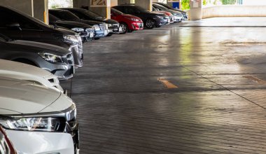 Bangkok, Tayland - 06 Haziran 2021: İş günlerinde apartmanda park edilmiş farklı araçlar. Park etmiş arabalarla dolu bir otopark. İnsanlar COVID-19 salgını sırasında evde kalıyor. Otopark alanı, odaklanma ve bulanıklık.