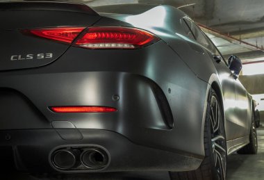 Bangkok, Tayland - 08 Haziran 2021: Arka lambaya yakın çekim, egzoz borusu ve park yerine park edilmiş siyah Mercedes spor arabası. Seçici odak.