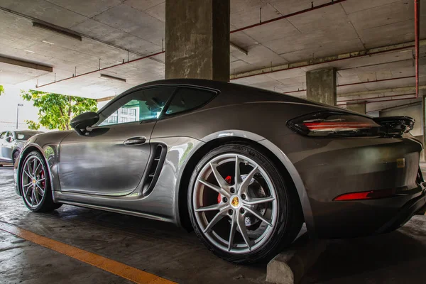 Bangkok, Tayland - 26 Haziran 2021: Arka ışık veya arka lambaya yakın çekim ve park yerine park edilmiş Porsche spor araba tekerleği. Seçici odak.
