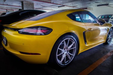 Bangkok, Tayland - 26 Haziran 2021: Arka lambaya yakın çekim veya arka lambaya yakın çekim, park yerine park edilmiş Sarı Porsche 'nin Tekerlek ve Kapısı spor arabası. Seçici odak.