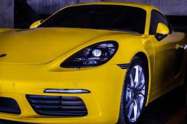 Bangkok, Tayland - 26 Haziran 2021: Otomobil Farları ve Sarı Porsche spor arabasının park alanına yakın çekim. Seçici odak.