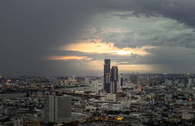 Bangkok, Tayland - 07 Temmuz 2021: Asya 'daki büyük metropol şehri üzerinde güzel bir günbatımı manzarası. Chao Phraya Nehri boyunca önemli ve izole binalar vardır. Seçici odak.
