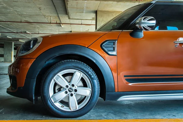 Bangkok, Tayland - 30 Haziran 2021: Far, Wheel, Hood, Sidelights ve park yerine park etmiş güzel kahverengi mini Cooper 'ın yan görüntüsü. Seçici odak.
