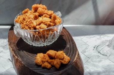 Mermer masanın üzerindeki cam kasede domuz eti çatırdatan biber ezmesi (Nam prik kag moo). Kızarmış acı biber ve kızarmış domuz eti, Tayland usulü yemek baharatları ve biber sosu, koruma konsepti, kopyalama alanı, seçmeli odaklanma..