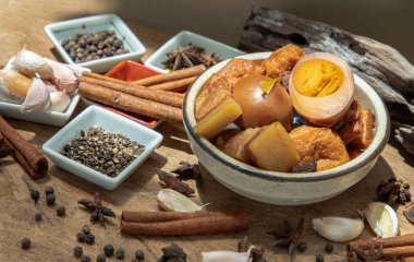 Haşlanmış yumurta (kai pa lo) ve Göbek Pork Çin beş baharatlı baharatlı soya peyniri anason yıldızı, tarçın, sarımsak ve karabiber ile süslenmiş kahverengi soslu eski ahşap masa, Asya yemeği, seçici odak noktası.