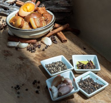 Haşlanmış yumurta (kai pa lo) ve Göbek Pork Çin beş baharatlı baharatlı soya peyniri anason yıldızı, tarçın, sarımsak ve karabiber ile süslenmiş kahverengi soslu eski ahşap masa, Asya yemeği, seçici odak noktası.