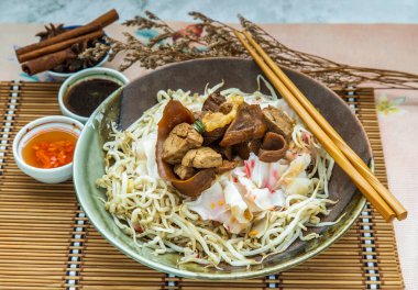 Çin usulü pilav eriştesi ve seramik tabakta fasulye filizi ile servis edilen acı biberli tatlı soya soslu haşlanmış domuz eti. Asya yemek tarzı, seçici odaklanma.