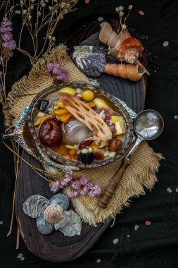 Tatlı tatlı: Çin tatlısının kaynamış şeker şuruplu hali burada çok lezzetlidir. Yeşil fasulye, nilüfer tohumu, darı, hurma, jöle, longan, haşlanmış un ve şeker de dahil olmak üzere pek çok tahıl var. Seçici odak.