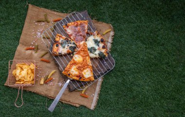 Domatesli lezzetli İtalyan pizzası, mozarella peyniri, ıspanak, pastırma, siyah zeytin ve patates cipsiyle servis edilen fesleğen. Lezzetli İtalyan pizzası, İtalyan yemeği konsepti, seçici odaklanma, kopyalama alanı..