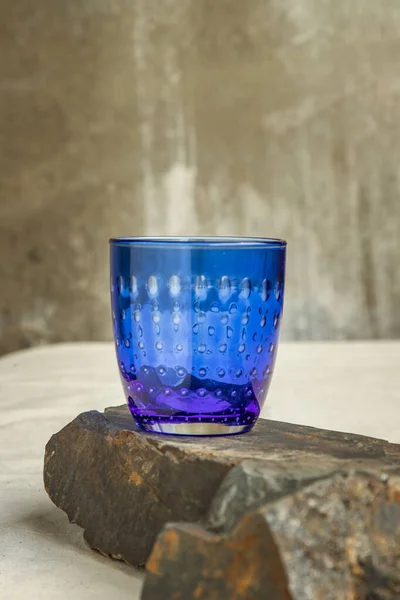 Een Blauwe Glazen Beker Voor Water Drinken Oppervlaktereflecties Rotsbodem Kopieerruimte — Stockfoto