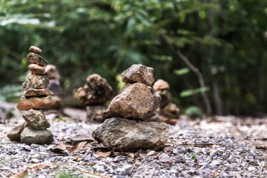 Arka planda yeşil bitkiler olan dağdaki dengeli taş kule. Boşluğu kopyala, Seçici odak.