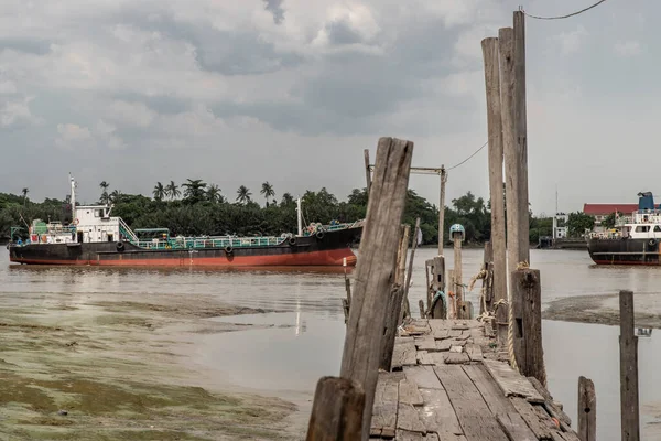 バンコク 2020年7月10日 チャオプラヤー川の古い壊れた木製桟橋と貨物船を背景に — ストック写真