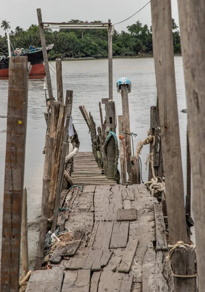 背景に貨物船とチャオプラヤ川の古い壊れた木製の桟橋 — ストック写真